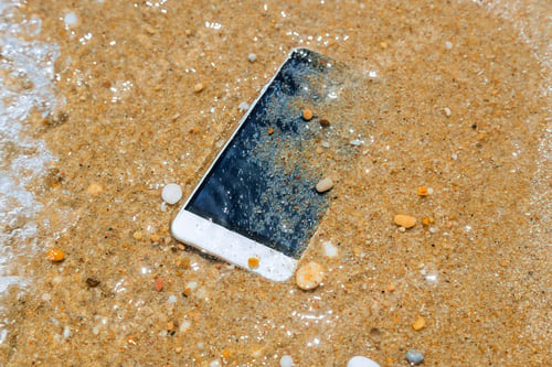 Preview: Phone dropped into the water of sea background with light reflected under the sea water.