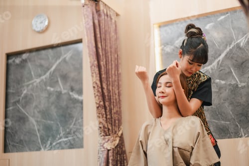Preview: A serene spa setting where a skilled therapist gives a woman a relaxing back massage.