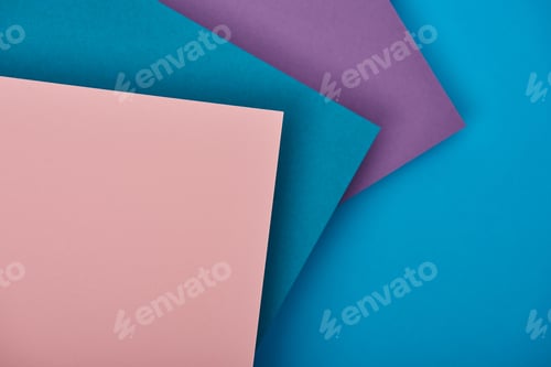 Preview: top view of blue, purple and pink paper sheets with copy space