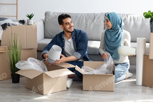 Preview: Loving arab family unpacking belongings from paper boxes