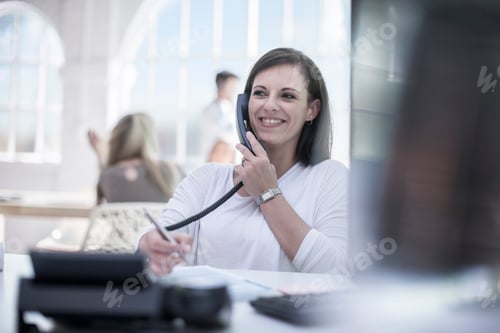 Preview: Female designer talking on telephone at design studio