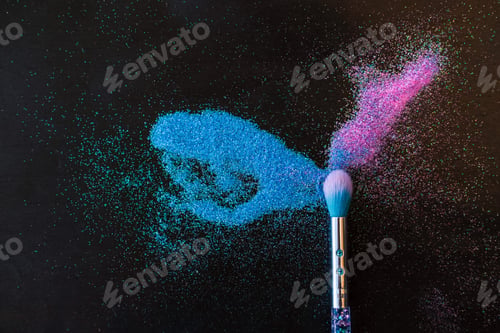 Preview: Makeup brush and shiny pink and blue sequins on a black background.
