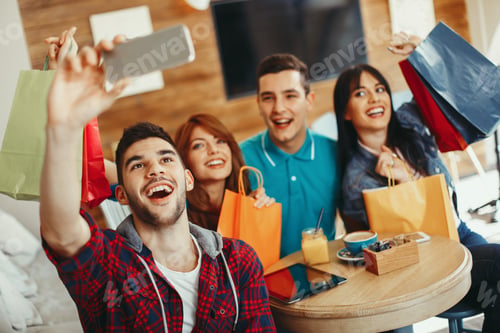 Preview: Group of young people doing selfie in a cafe after shopping