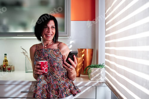 Preview: Woman drinking coffee during a video call at home