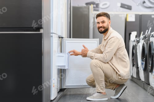 Preview: Customer choosing new refrigerator in electronics store showing thumbs up
