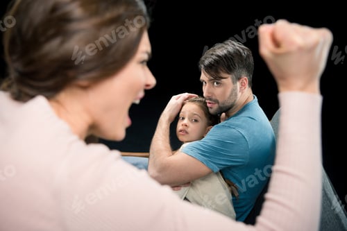 Preview: father protecting daughter from aggressive mother isolated on black, family violence concept