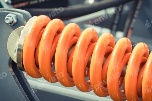 Preview: Hard orange spring made of steel. Part of big industrial or agricultural machine
