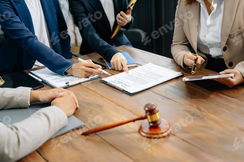 Preview: business people and lawyers discussing contract papers sitting at the table.