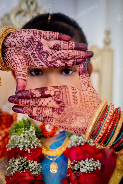 Preview: Close-up shot of a girl with colorful jewelry, posing with her hands in intricate henna designs