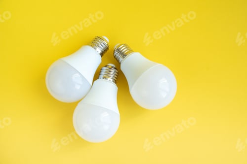 Preview: Three LED light bulbs on yellow background. energy saving concept