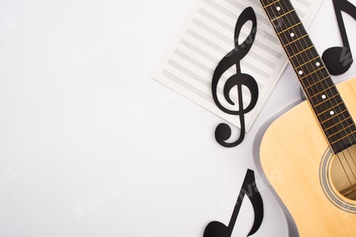 Preview: Top view of paper cut notes with music book and acoustic guitar on white background