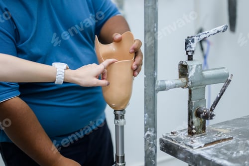 Preview: Prosthetic technician holding prosthetic leg checking and controlling