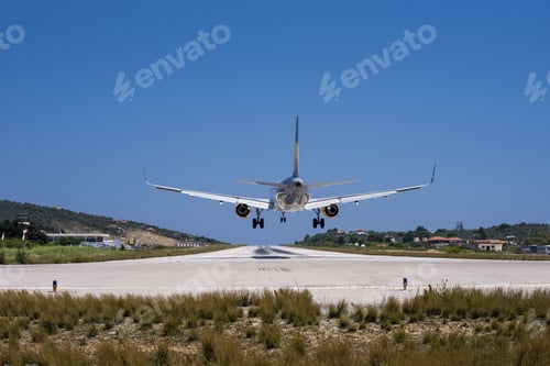 Preview: Closeup shot of a plane landing in a small airport with houses and forests on the background