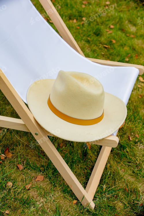 Preview: Wooden chair and hat in a garden