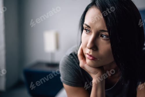 Preview: selective focus of beautiful depressed woman looking away at home