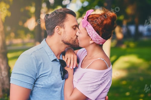 Preview: Portrait of bearded male and redhead female in a city park.