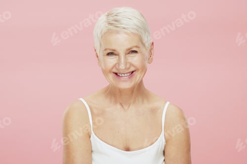 Preview: Beauty portrait of beautiful senior woman with perfect fresh skin on her face, isolated on pink