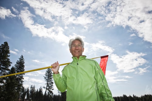Preview: A young asian senior man ready to hit his next golf shot on a golf course.