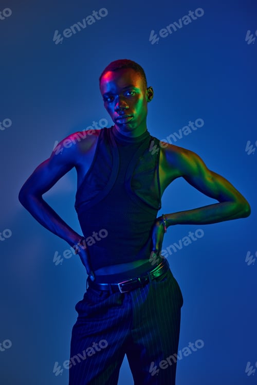 Preview: Stylish young man showcasing vibrant colors with confidence in a contemporary setting