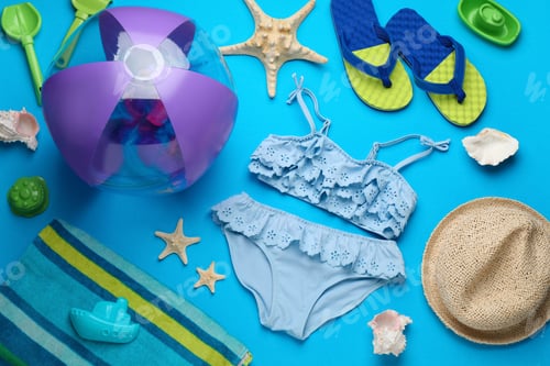 Preview: Flat lay composition with beach ball and sand toys on light blue background, space for text