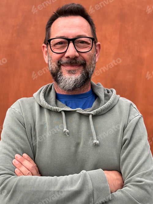 Preview: Portrait of adult man smiling and looking in front wearing glasses and green sweater