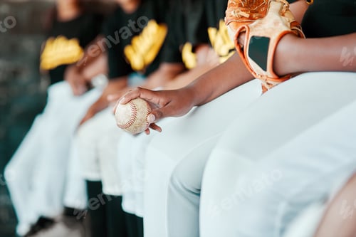 Preview: Cropped shot of a group of young baseball players sitting together on the bench during a game