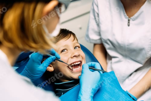 Preview: Dentists with a patient during a dental intervention to boy.
