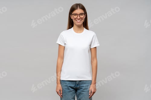 Preview: Woman in casual white t-shirt standing isolated on gray background, template or mockup for logo
