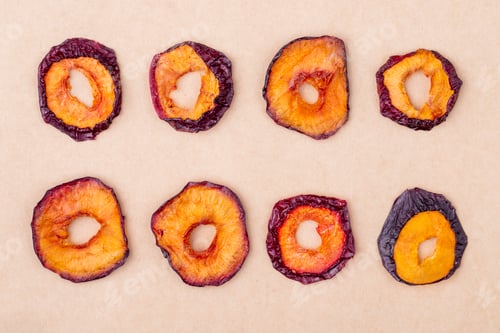 Preview: top view of dried plum slices isolated on brown paper texture background