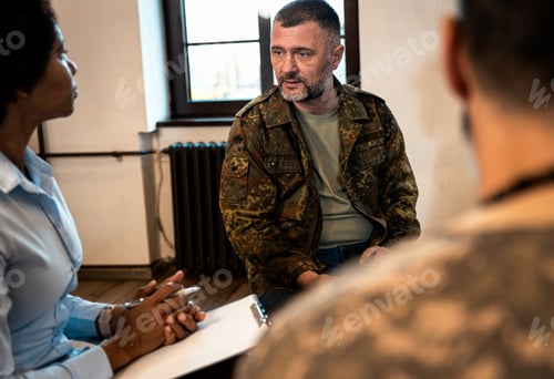 Preview: Group of diverse veterans talking during PTSD support group.