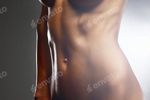 Preview: Mid section of a naked model isolated against colored background