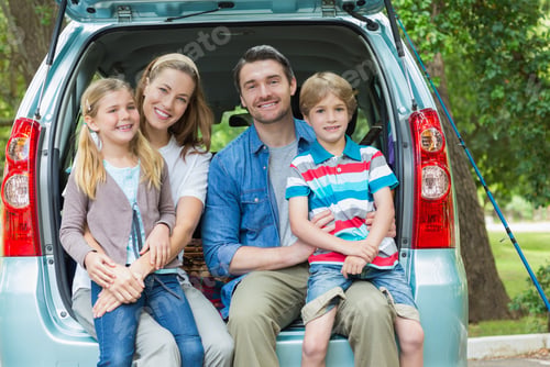 Preview: Portrait Of A Happy Family Of Four Sitting In Car Trunk While On Picnic