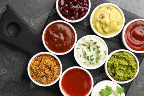 Preview: Different tasty sauces in bowls on grey table, top view