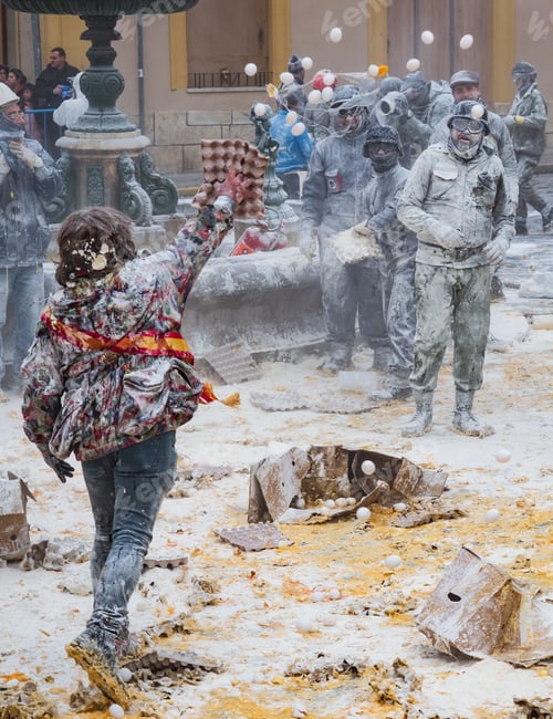Preview: Ibi, Spain - December, 28 2018: People throwing eggs and flour at each other