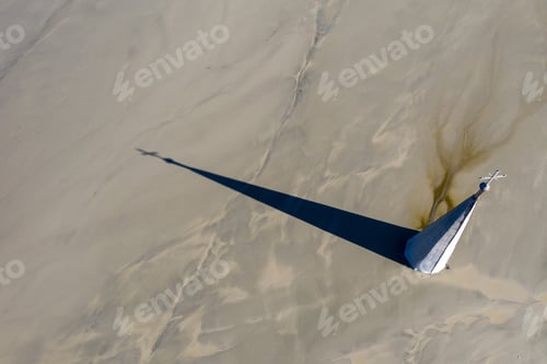 Preview: Aerial view of a church tower with cross, buried under mud and mining residuals