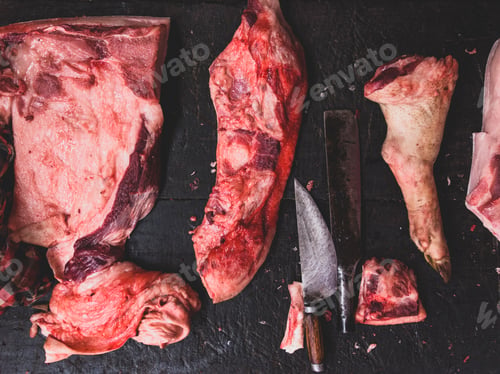 Preview: meat raw assortment and knife on the butcher's dark wooden worki