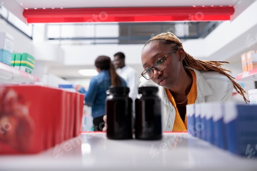 Preview: African american woman taking medication bottles from drugstore shelf