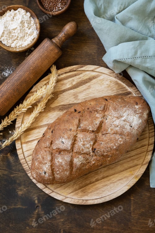 Preview: Bread from whole wheat grains, wheat bran, seeds, bio-ingredients over rustic table background.