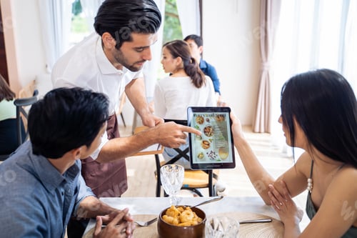 Preview: Caucasian waiter receiving order serving from customer in restaurant.