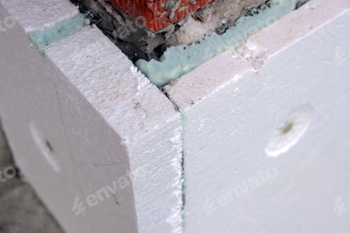 Preview: Close-up detail of brick house wall with rigid styrofoam insulation sheet.