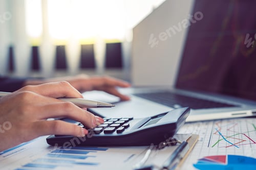 Preview: Close-up business women using a calculator and a laptop to calculate the company's financial results