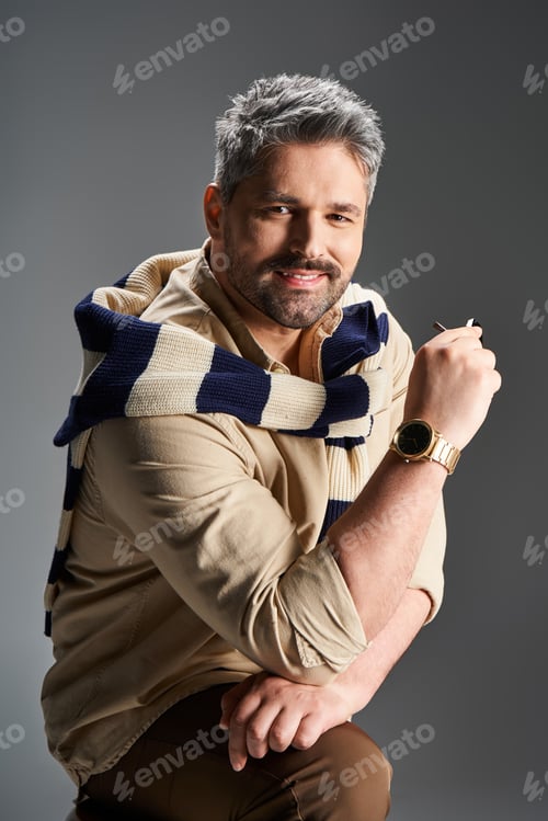 Preview: Handsome man in stylish outfit poses confidently in a studio setting