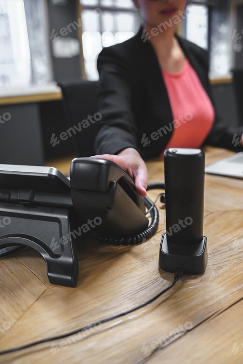 Preview: Crop woman with telephone in modern workplace