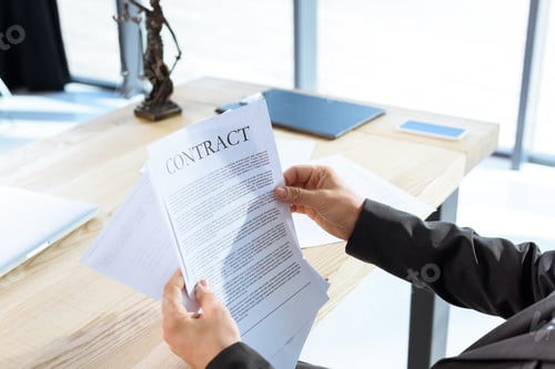 Preview: cropped shot of businessman reading contract at workplace