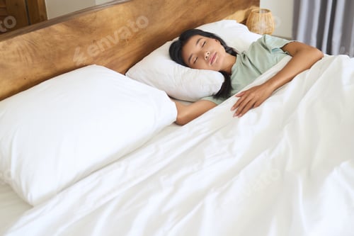 Preview: Woman Sleeping Comfortably in a Cozy White Bed
