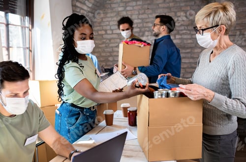 Preview: Group of volunteers with working in community charity donation center.
