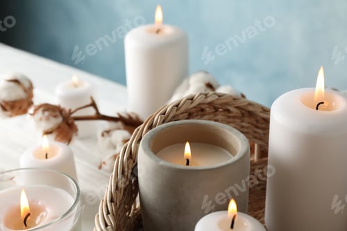 Preview: Burning candles, basket and cotton on white wooden background, close up