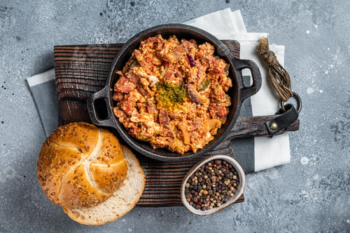 Preview: Turkish breakfast with Menemen omelet and bread. Dark background. Top view