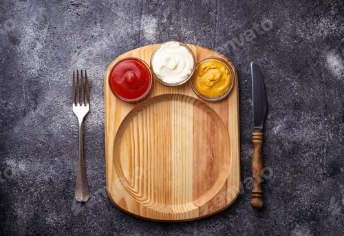 Preview: Food background with mustard, ketchup, mayonnaise, fork and knife.