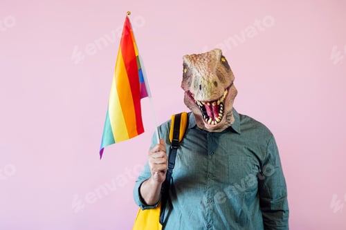 Preview: Man with lizard mask on pink background with colorful pride flag.